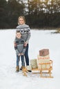 Parent and child with sleigh, winter sledding, outdoor activity. Christmas vacation, family, son and mother with Royalty Free Stock Photo