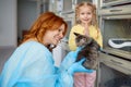 Mother holding little kitten and her daughter folding hand in pray position