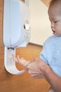 Parent cleaning toddler hand with waterless hand sanitizer, anti-bacterial hand disinfectant from sanitizer dispenser - Selective