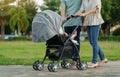 parent (father and mother) pushing infant baby stroller and walking in park Royalty Free Stock Photo