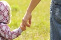 Parent holds the hand of a child