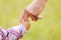 Parent holds the hand of a small child