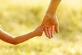 Parent holds the hand of a small child