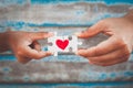 Parent and kid hands connecting couple jigsaw puzzle with drawn red heart