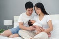 parent (mother and father) holding and consoling newborn baby to sleeping on bed Royalty Free Stock Photo