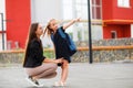 Mom leads her daughter to school. Return to school. Woman and girl with backpack behind the back. Beginning of lessons Royalty Free Stock Photo