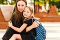 Mom leads her daughter to school. Return to school. Woman and girl with backpack behind the back. Beginning of lessons Royalty Free Stock Photo