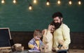 Parent support concept. Parents watching their son drawing, learning to write, chalkboard on background. Boy on busy Royalty Free Stock Photo