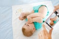 Parent taking photo of a baby with smartphone. Adorable newborn child taking foot in mouth Royalty Free Stock Photo