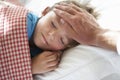 Parent Taking Temperature Of Young Boy Asleep In Bed Royalty Free Stock Photo