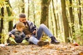 Parent teach baby. Dad and son using laptop the park. Father and son playing in the autumn forest.