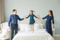 Parental care concept. Happy family jumping on the bed