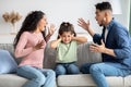 Parental Conflicts. Upset Little Girl Covering Ears Not To Listen Parents Arguing Royalty Free Stock Photo