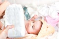 Parental hand holds stack of diapers baby on changing table