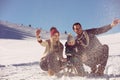 Parenthood, fashion, season and people concept - happy family with child on sled walking in winter outdoors