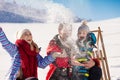 Parenthood, fashion, season and people concept - happy family with child on sled walking in winter outdoors