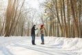 Parenthood, fashion, season and people concept - happy family with child in winter clothes walking outdoors.