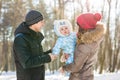 Parenthood, season and people concept - happy family with child in winter clothes outdoors