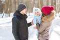 Parenthood, season and people concept - happy family with child in winter clothes outdoors