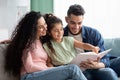 Parenting Concept. Happy Young Arab Parents Reading Book With Their Child Royalty Free Stock Photo