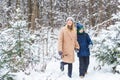 Parenting, fun and season concept - Happy mother and son having fun and playing with snow in winter forest