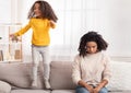 Exhausted Mother Sleeping While Hyperactive Daughter Jumping On Sofa Indoor