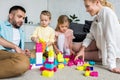 parents with adorable little kids sitting on carpet and playing Royalty Free Stock Photo