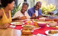 Parents With Adult Offspring Sitting Around Table At Home Enjoying Meal Together Royalty Free Stock Photo