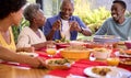 Parents With Adult Offspring Sitting Around Table At Home Enjoying Meal Together Royalty Free Stock Photo