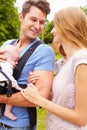 Parents With Baby In Carrier On Walk In Countryside