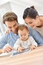 Parents with baby girl using tablet