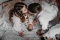 Parents with baby kissing on white bed at home in the morning Royalty Free Stock Photo