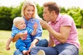 Parents Blowing Bubbles For Young Boy In Garden Royalty Free Stock Photo