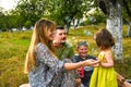 Parents blowing soap bubbles to child. Family love first. Family activity leisure outdoor in autumn park. Mother, father