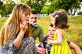 Parents blowing soap bubbles to child. Family love first. Family activity leisure outdoor in autumn park. Mother, father and two