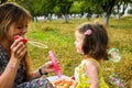 Parents blowing soap bubbles to child. Family love first. Family activity leisure outdoor in autumn park. Mother, father