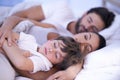 Parents, boy and sleeping in bedroom, home and embrace for rest, peace and quiet with bonding. Father, mother and child