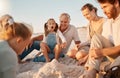 Parents building a sandcastle with their children. Family enjoying a beach holiday together. Little girls playing with Royalty Free Stock Photo