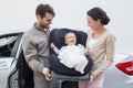 Parents carrying baby in his car seat