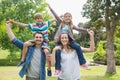 Parents carrying kids on shoulders at park Royalty Free Stock Photo