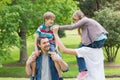 Parents carrying kids on shoulders at park Royalty Free Stock Photo