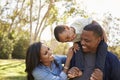 Parents Carrying Son On Shoulders As They Walk In Park Royalty Free Stock Photo