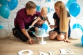 Parents are celebrating first birthday of their son and feeding his by cake