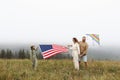 parents and child with American flag are playing with a colorful kite. mother, father and their little daughter Royalty Free Stock Photo