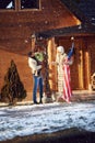 Parents and child decorate house together outdoor for Christmas