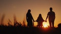 Parents with the child stand in a picturesque place, admiring the sunrise. Holding hands. Happy family concept Royalty Free Stock Photo