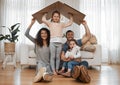 Parents, children and cardboard roof in portrait, smile or excited for security, real estate or fresh start in family