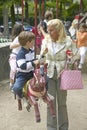 Parents and children at carousel ride in park, Paris, France