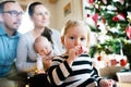 Parents with children at Christmas tree blowing party whistle