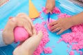 Parents and children happily play in the space sand